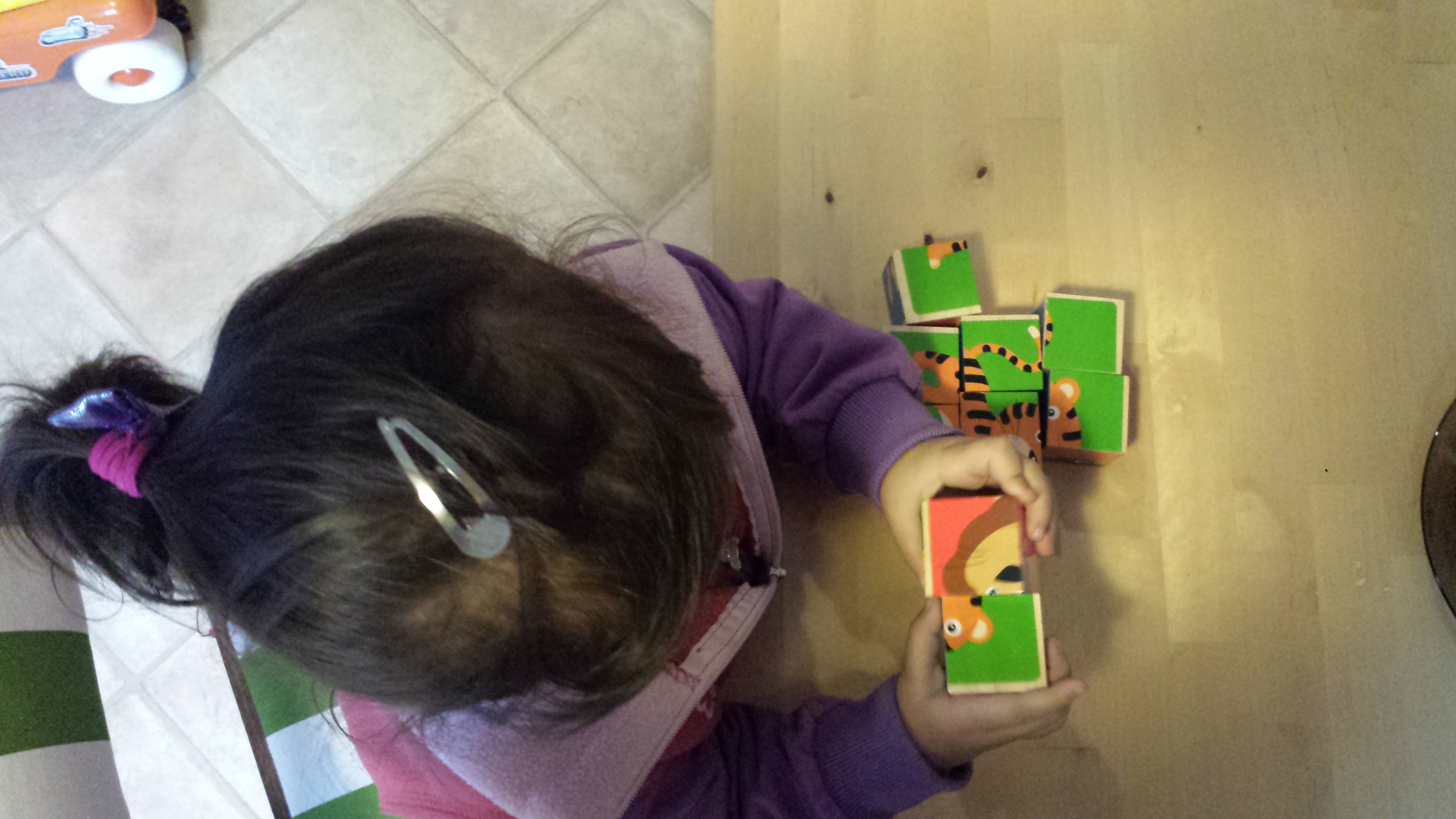 zdjęcie dziecka układającego puzzle sześcienne